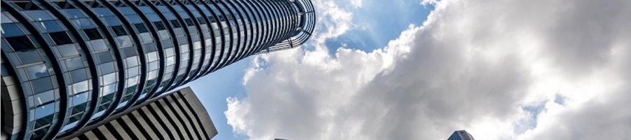 Hochhäuser Hochhäuser von unten fotografiert. Die Sonne scheint durch den Himmel durch.