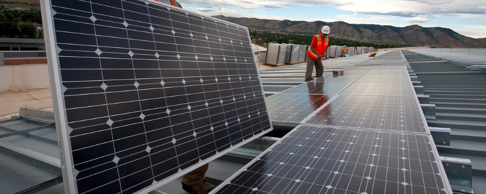 Arbeiter bauen eine Photovoltaikanlage auf.